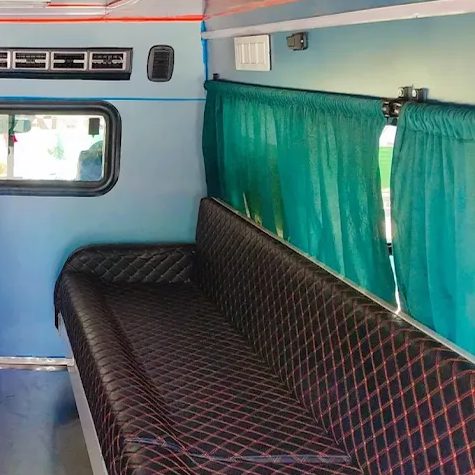Quilted bench seating and curtains inside an R.N Ambulance Service vehicle